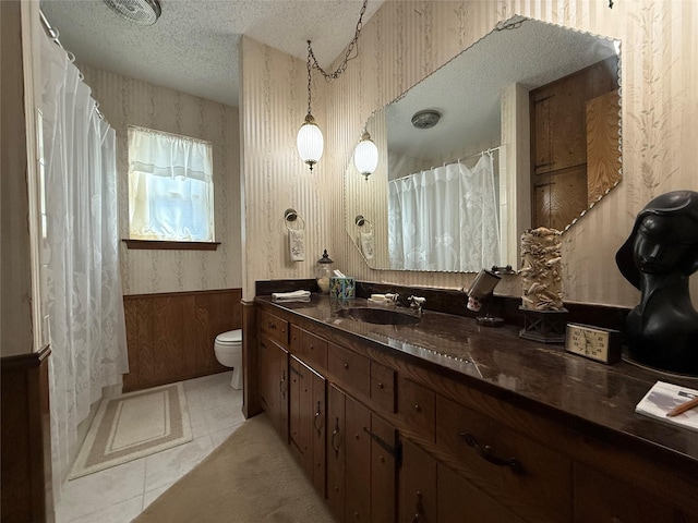 bathroom with tile patterned floors, toilet, a textured ceiling, and vanity