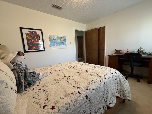 carpeted bedroom with a closet and a textured ceiling