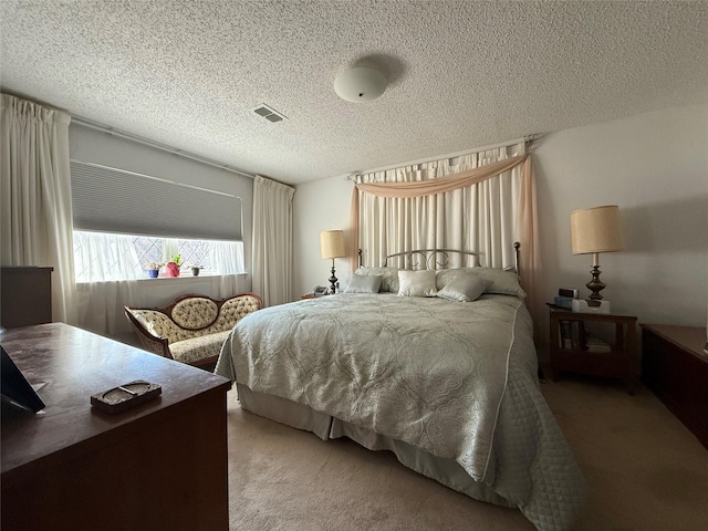 bedroom with carpet floors and a textured ceiling