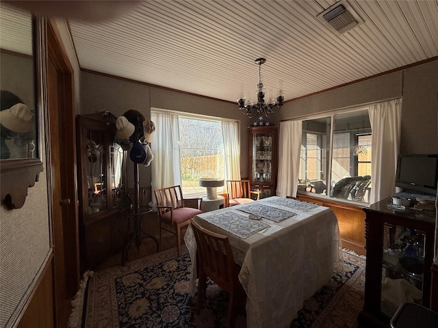 dining room with crown molding and an inviting chandelier