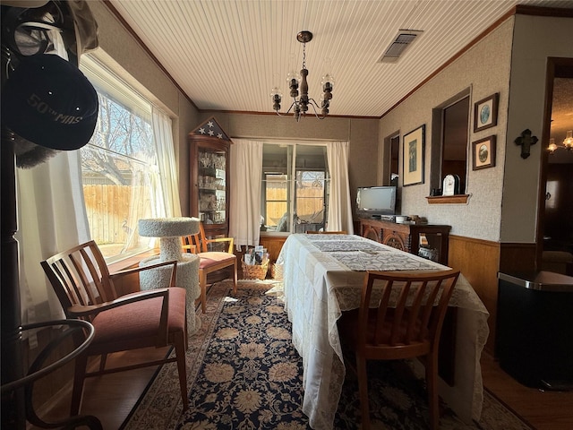 dining room featuring crown molding, plenty of natural light, an inviting chandelier, and wood-type flooring