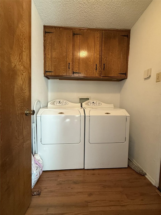 laundry room featuring separate washer and dryer, dark hardwood / wood-style floors, cabinets, and a textured ceiling