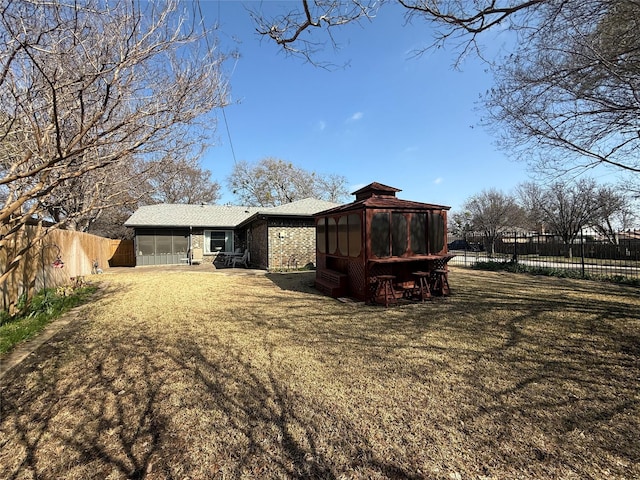 back of house featuring a sunroom and a yard