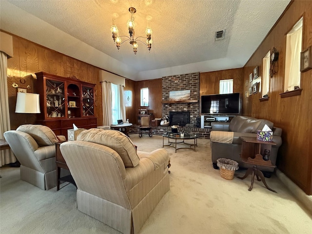 carpeted living room featuring a brick fireplace, a chandelier, a textured ceiling, and wooden walls