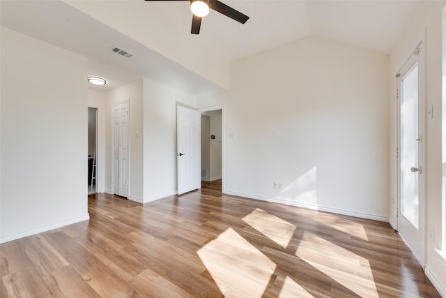 empty room with ceiling fan, lofted ceiling, and light wood-type flooring