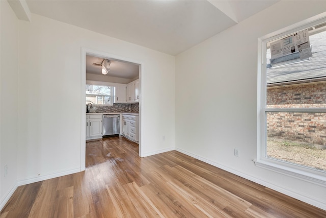 unfurnished living room with sink and light hardwood / wood-style flooring