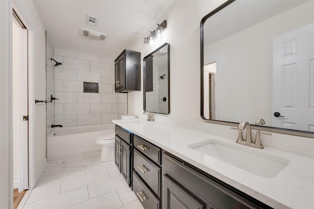 full bathroom featuring tiled shower / bath, vanity, and toilet