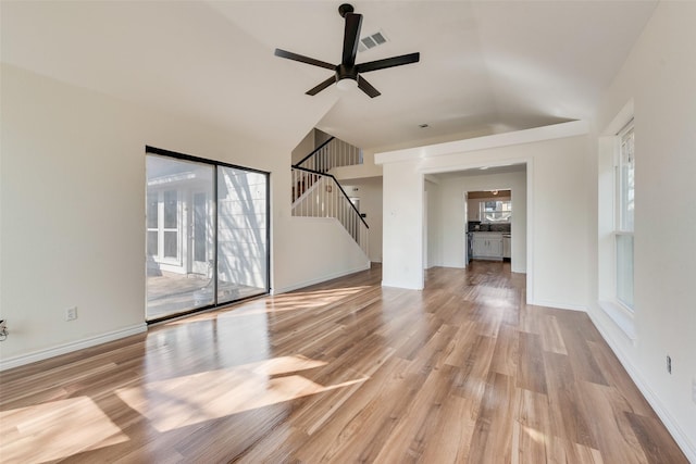 unfurnished living room featuring ceiling fan, vaulted ceiling, and light wood-type flooring