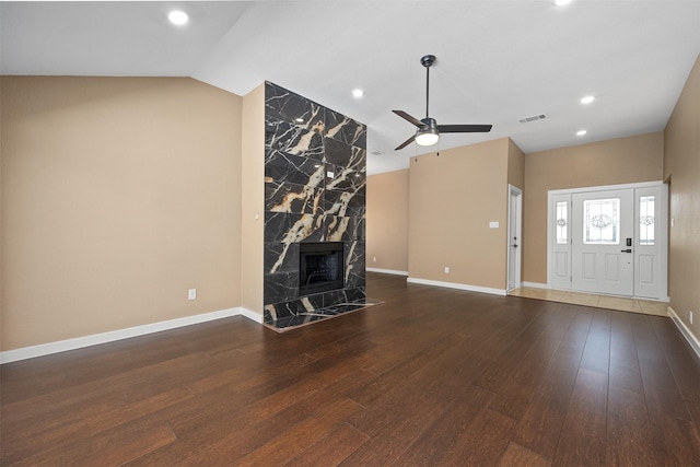 unfurnished living room with ceiling fan, a high end fireplace, dark hardwood / wood-style floors, and lofted ceiling