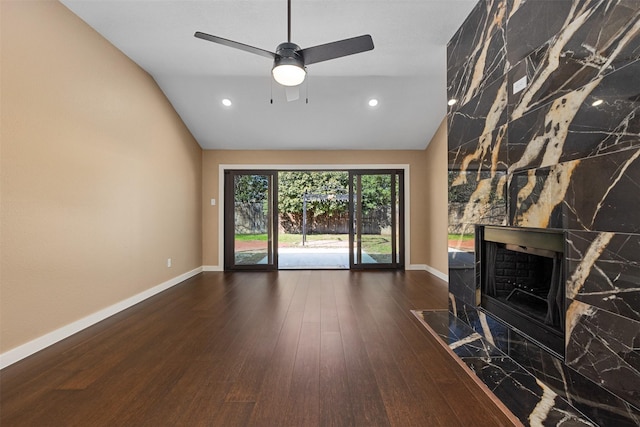 unfurnished living room featuring a fireplace, dark hardwood / wood-style floors, ceiling fan, and vaulted ceiling