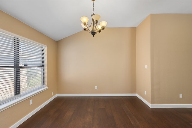 empty room with dark hardwood / wood-style flooring, a notable chandelier, and vaulted ceiling