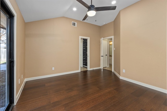 unfurnished bedroom with lofted ceiling, ceiling fan, connected bathroom, dark hardwood / wood-style flooring, and a walk in closet