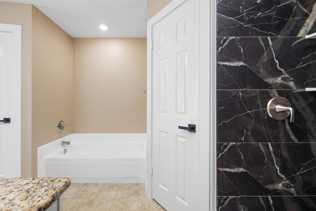 bathroom with a tub to relax in and tile patterned flooring