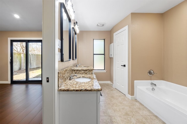 bathroom with vanity, a bath, and tile patterned flooring