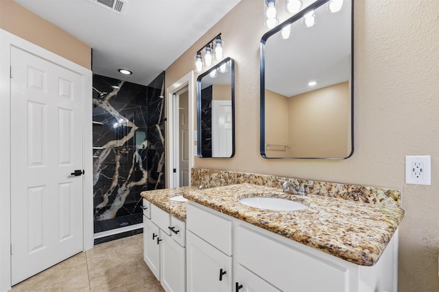 bathroom with tiled shower and vanity