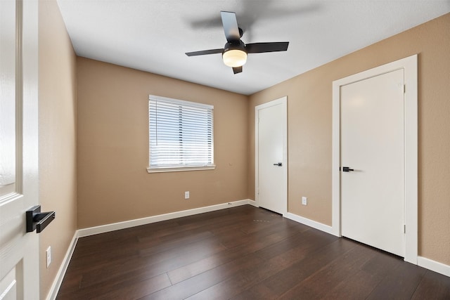 unfurnished bedroom featuring ceiling fan and dark hardwood / wood-style flooring