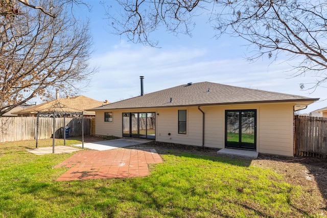 back of house with a patio and a lawn