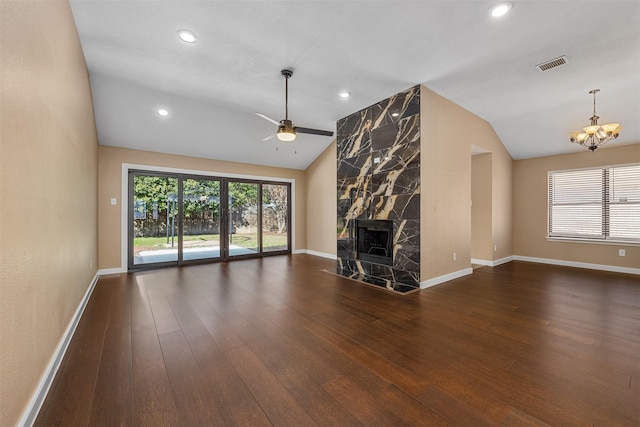 unfurnished living room with dark hardwood / wood-style floors, lofted ceiling, a premium fireplace, and plenty of natural light