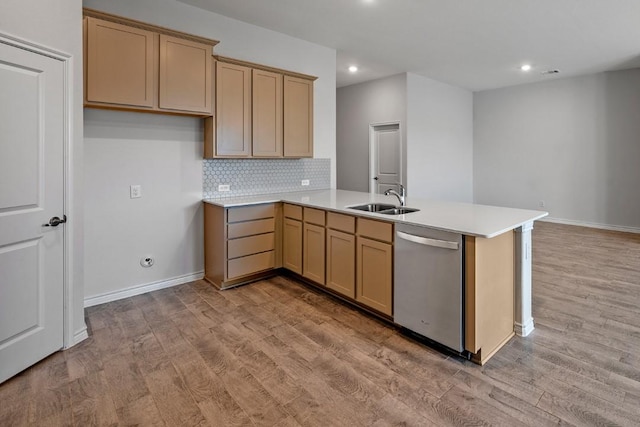 kitchen featuring sink, dishwasher, light hardwood / wood-style floors, decorative backsplash, and kitchen peninsula