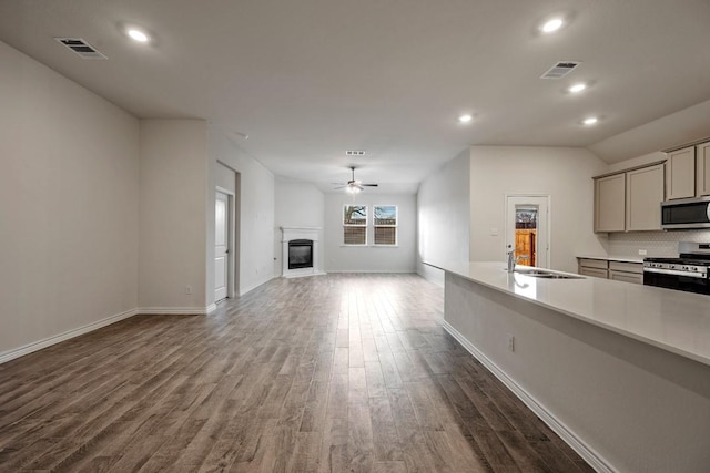 kitchen with appliances with stainless steel finishes, sink, gray cabinetry, ceiling fan, and dark wood-type flooring