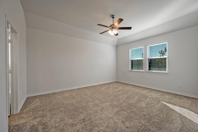 carpeted spare room with vaulted ceiling and ceiling fan