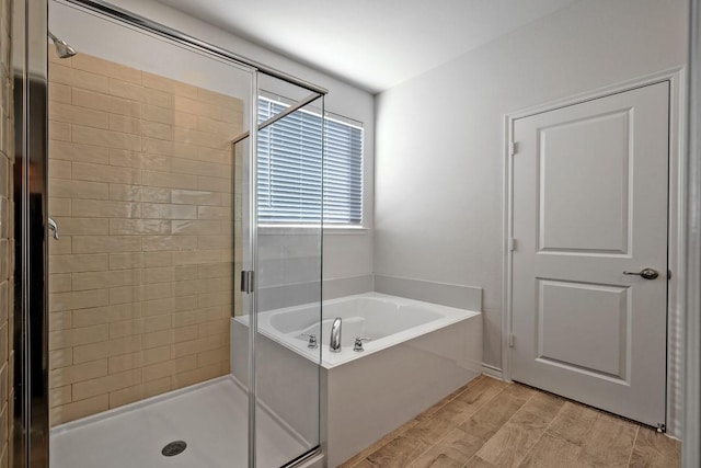 bathroom featuring hardwood / wood-style floors and plus walk in shower