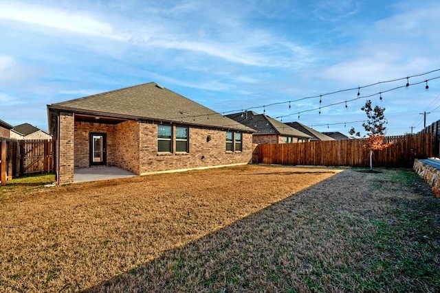 back of property with a patio and a lawn