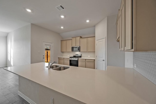 kitchen with lofted ceiling, sink, kitchen peninsula, stainless steel appliances, and decorative backsplash