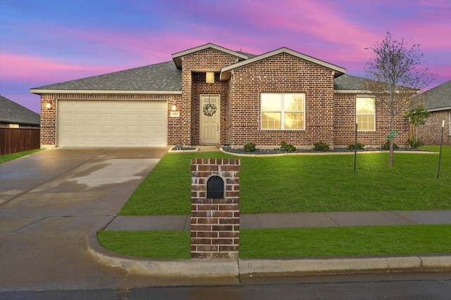 ranch-style house featuring a garage, driveway, a shingled roof, a front yard, and brick siding