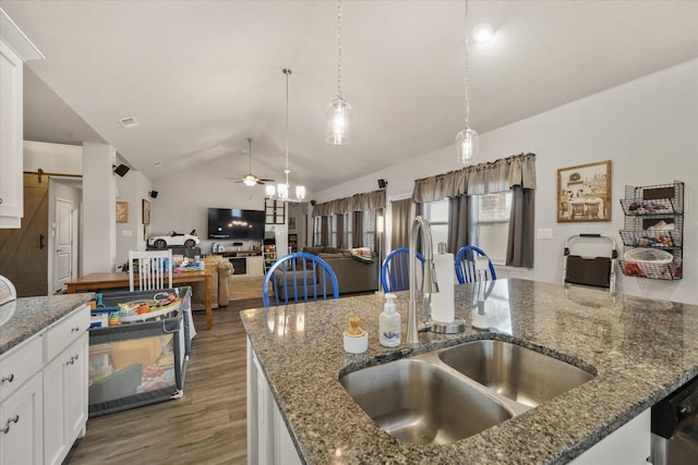 kitchen featuring pendant lighting, lofted ceiling, a ceiling fan, a sink, and wood finished floors