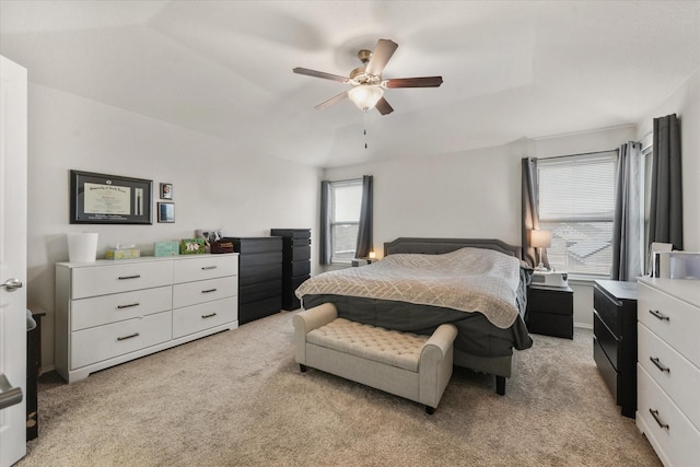 bedroom featuring light carpet, baseboards, and a ceiling fan