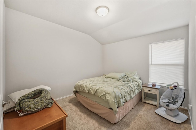 bedroom featuring lofted ceiling, baseboards, and light colored carpet