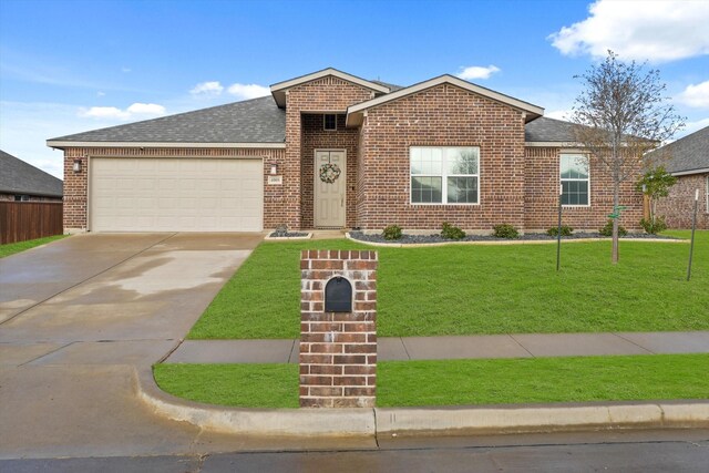 view of front of property featuring a garage and a front lawn