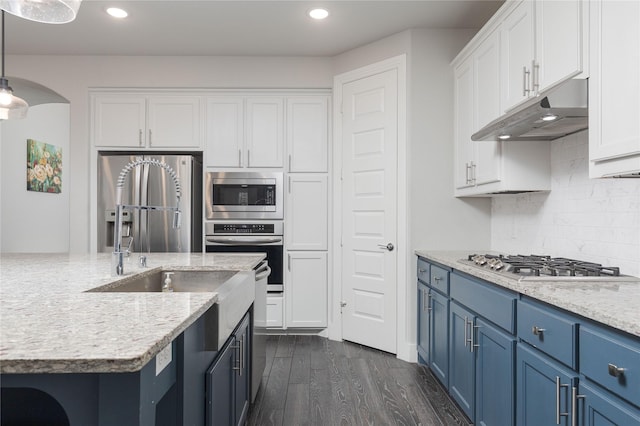 kitchen with blue cabinets, decorative light fixtures, appliances with stainless steel finishes, light stone countertops, and white cabinets