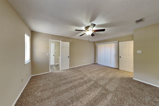 unfurnished room with ceiling fan, carpet floors, and a textured ceiling