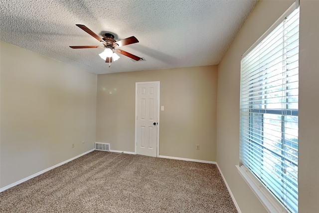 unfurnished room with ceiling fan, carpet floors, and a textured ceiling