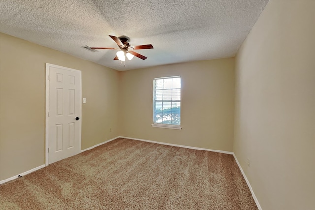 spare room with a textured ceiling, ceiling fan, and carpet