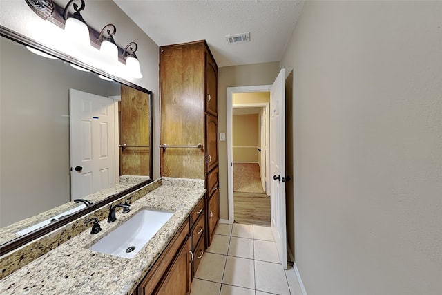 bathroom with vanity, tile patterned floors, and a textured ceiling