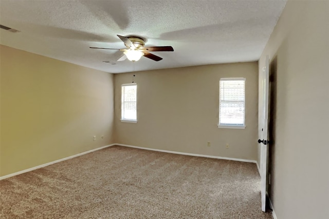 carpeted spare room with ceiling fan and a textured ceiling