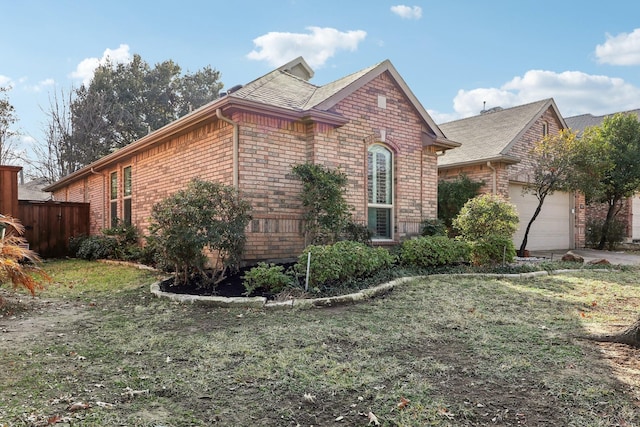 view of side of property featuring a garage and a yard