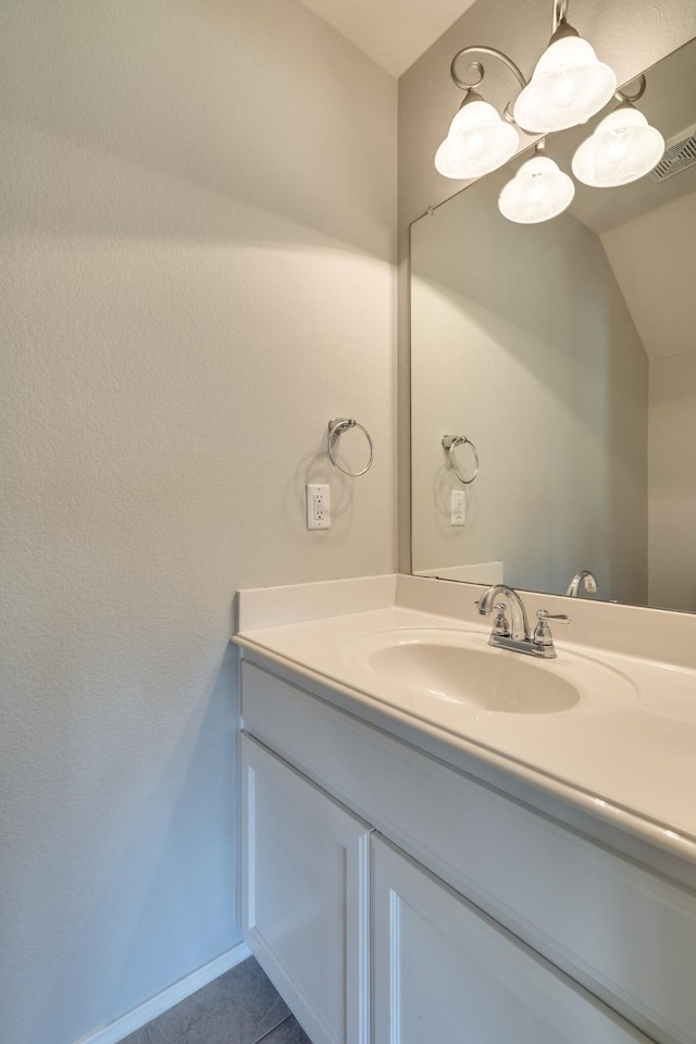 bathroom featuring vanity, a notable chandelier, tile patterned flooring, and lofted ceiling