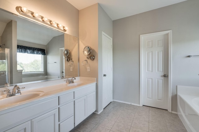 bathroom featuring vanity, a bath, and tile patterned floors