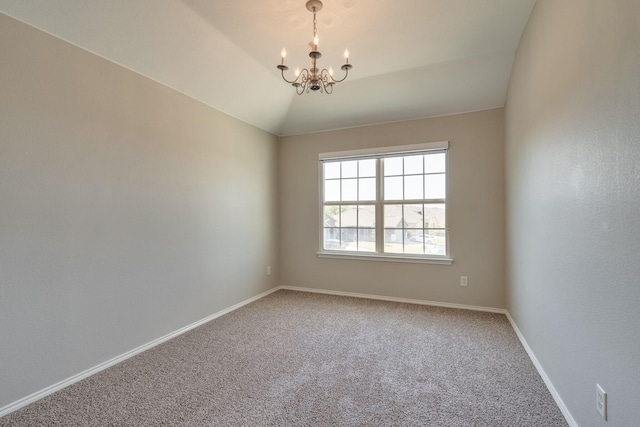 spare room with carpet floors, vaulted ceiling, and a chandelier