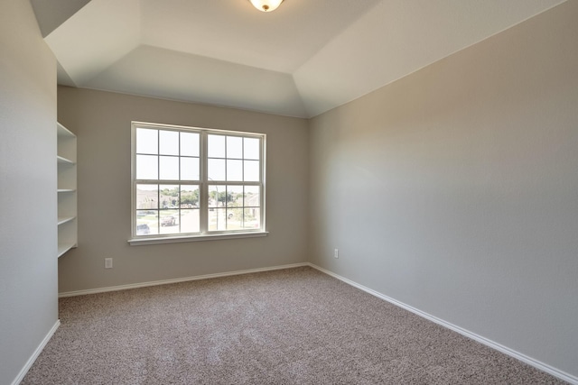 carpeted spare room with lofted ceiling