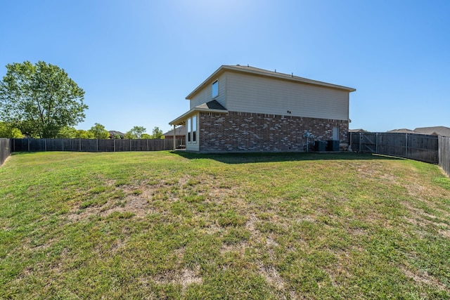 rear view of property with central AC and a lawn