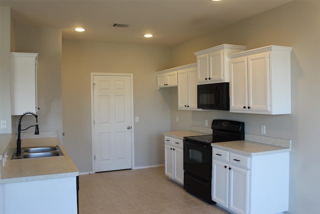 kitchen with white cabinetry, sink, light tile patterned flooring, and black appliances