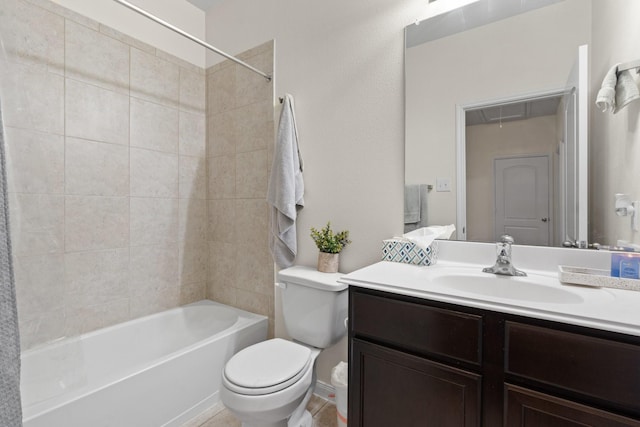 full bathroom featuring tiled shower / bath, vanity, and toilet