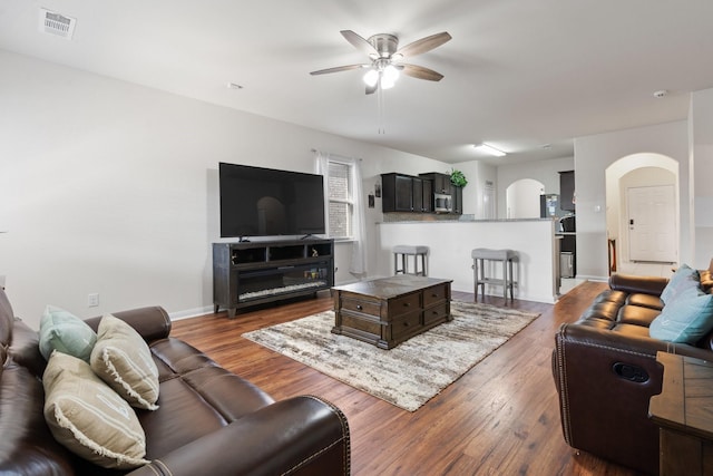 living room with dark hardwood / wood-style floors and ceiling fan