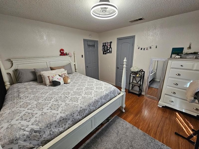 bedroom featuring dark hardwood / wood-style floors and a textured ceiling