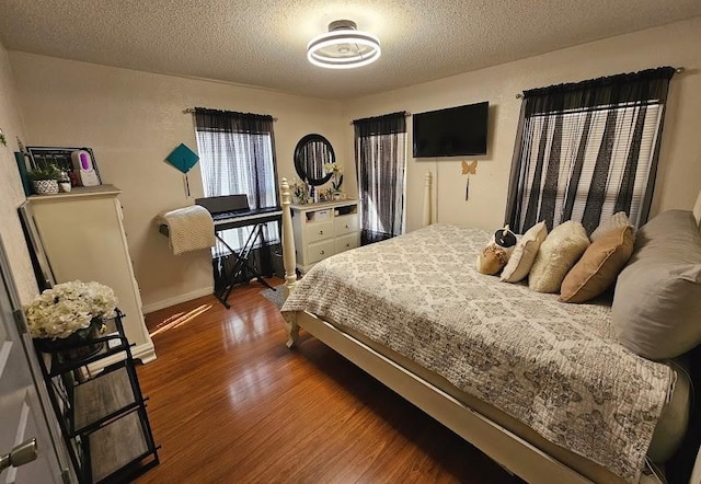 bedroom with a textured ceiling and dark hardwood / wood-style flooring